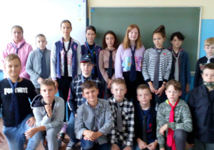 Na zdjęciu uczniowie klasy VI b ubrani w krawaty na tle tablicy kredowej.