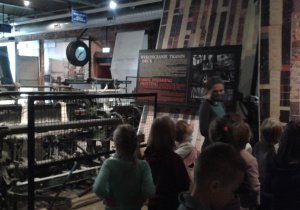 Uczniowie klasy 2a słuchają historię fabryki Izraela Poznańskiego.