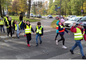Zdjęcie przedstawia uczniów przechodzących przez przejście dla pieszych, bez sygnalizacji świetlnej.