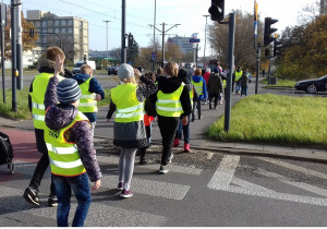 Zdjęcie przedstawia uczniów przechodzących przez przejście dla pieszych, bez sygnalizacji świetlnej.