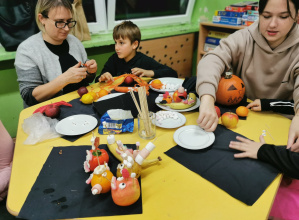 Rodzice i dzieci wspólnie tworzą smakołyki z warzyw.