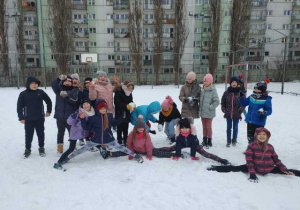 Uczniowie bawią się na śniegu.