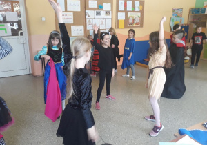 Zdjęcie przedstawia dzieci z klasy 2 w kostiumach, tańczące do muzyki podczas balu karnawałowego.
