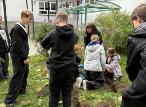 Uczniowie z rodzicami sadzą wiosenne kwiaty